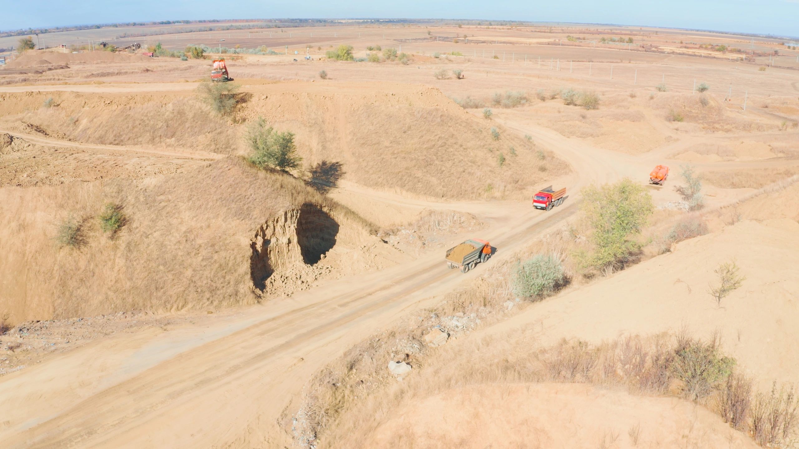 Dump trucks transporting ore material through an active mining site